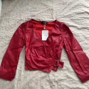 Röd skinntopp  - Rödskinntopp i perfekt skick, aldrig använd med prislapp kvar. Köpt från bershka. Storlek XS men funkar som S också. 