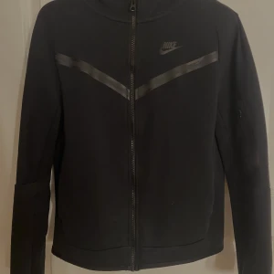  Nike Tech Fleece, svart - Säljer nu min fina ”Nike Tech Fleece” då den inte kommer till användning längre. Används ett fåtal gånger men är som ny och i jätte bra skick. Säljer för 900kr men priset kan diskuteras. Är flera intresserade blir de budgivning. 