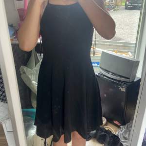 En svart klänning från Gina tricot som är köpt på seconhand men själv aldrig använts