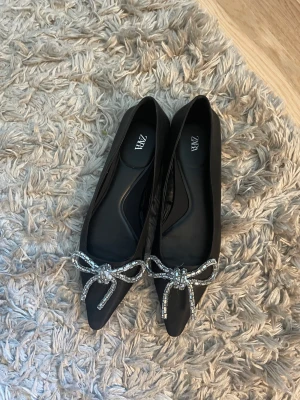 Ballerinaskor från zara  - Svarta ballerinaskor med rosetter från zara. Endast använda vid ett tillfälle så som nya. Storlek 38. Slutsålda på hemsidan. 