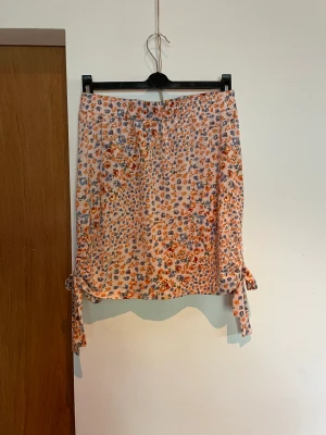 Tight kjol - Blommig tight kjol från glamourous.  Rosetter på var sida. 