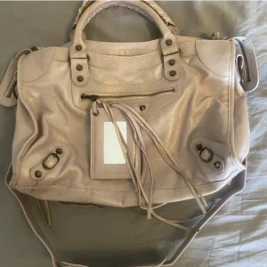 Äkta Balenciaga väska - Säljer min balenciaga city bag då den inte kommer till någon användning längre. Väska är i storlek medium och är i färgen ljus rosa hör av dig vid intresse. tar också imot byten💗