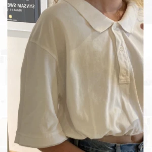 Oversized piké - ”Bet Pike Top” från Weekday. Justerbart spännband i midjan. Storlek M men oversized och croppad.