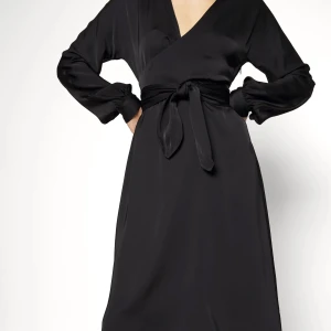 Svart omlottklänning - Svart långarmand klänning som köptes förra året som inte kom till användning. Storlek 36, 