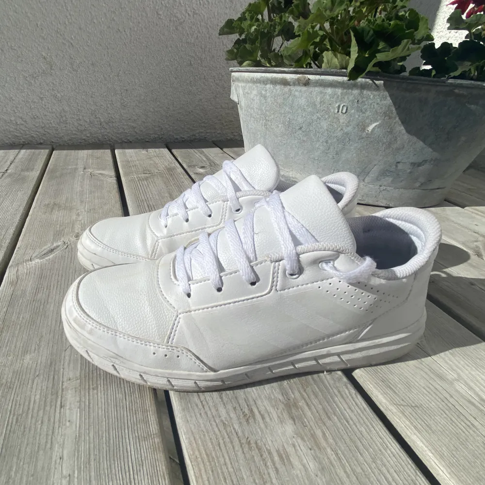 Vita adidas sneakers. Väl använda. Storlek 38 2/3 (lite större än 38). Liten fläck på vänster sko (se bild 2), tvättas innan frakt. Köparen står för frakt. . Skor.