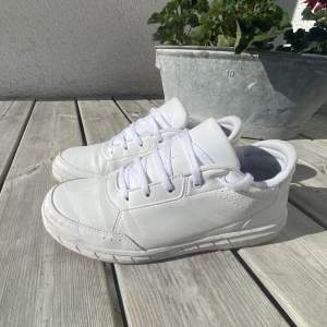 Vita adidas sneakers. Väl använda. Storlek 38 2/3 (lite större än 38). Liten fläck på vänster sko (se bild 2), tvättas innan frakt. Köparen står för frakt. 