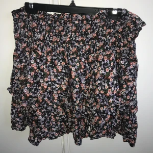 Svart volangkjol - En svart volangkjol med blommor på.