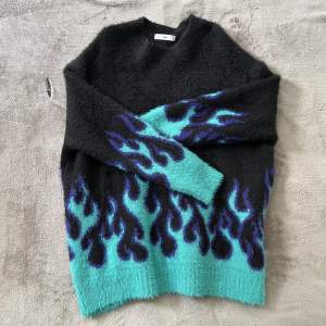Stickad tröja från Adika med mönster av blå eld, sitter som en oversized S eller en M🤍 Köparen står för fraktkostnad!