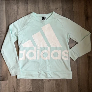 Adidas sweatshirt storlek L - En mintgrön/turkos sweatshirt i Adidas som är använd en gång. Jättefin
