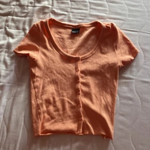 En aprikosfärgad t shirt  - En jätte skön t shirt med knappar , även lite cropped!