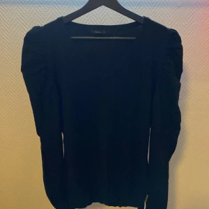 Stickad långärmad  - Stickad svart långärmad med puffiga axlar. Ett bra material och är i bra skick.