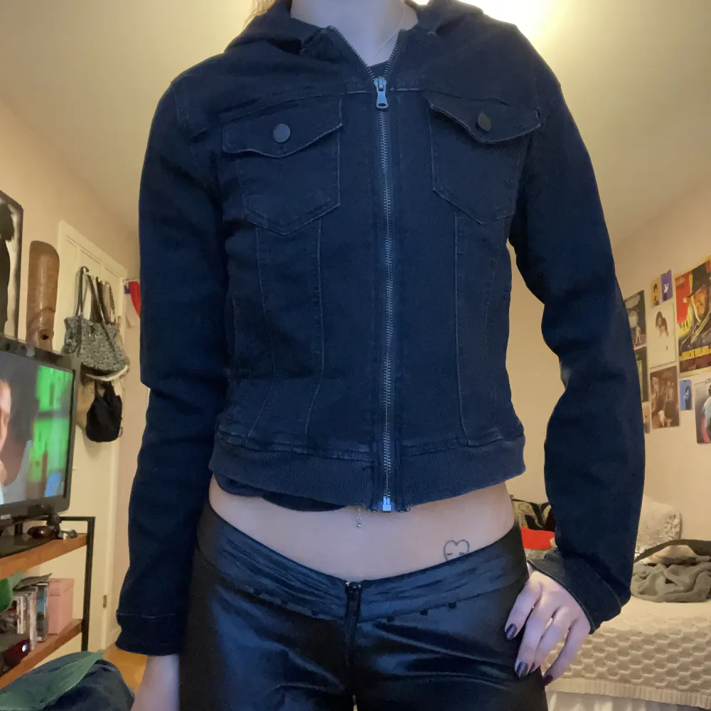 Svart, ganska kort jacka med stor luva. I tunnt jeans material, den är strechig. . Jackor.
