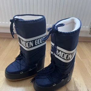 Moon Boot - Mörkblå Moon Boots i storlek 39-41. I mycket bra skick använda Max 3 ggr lite slitningar i snörena.