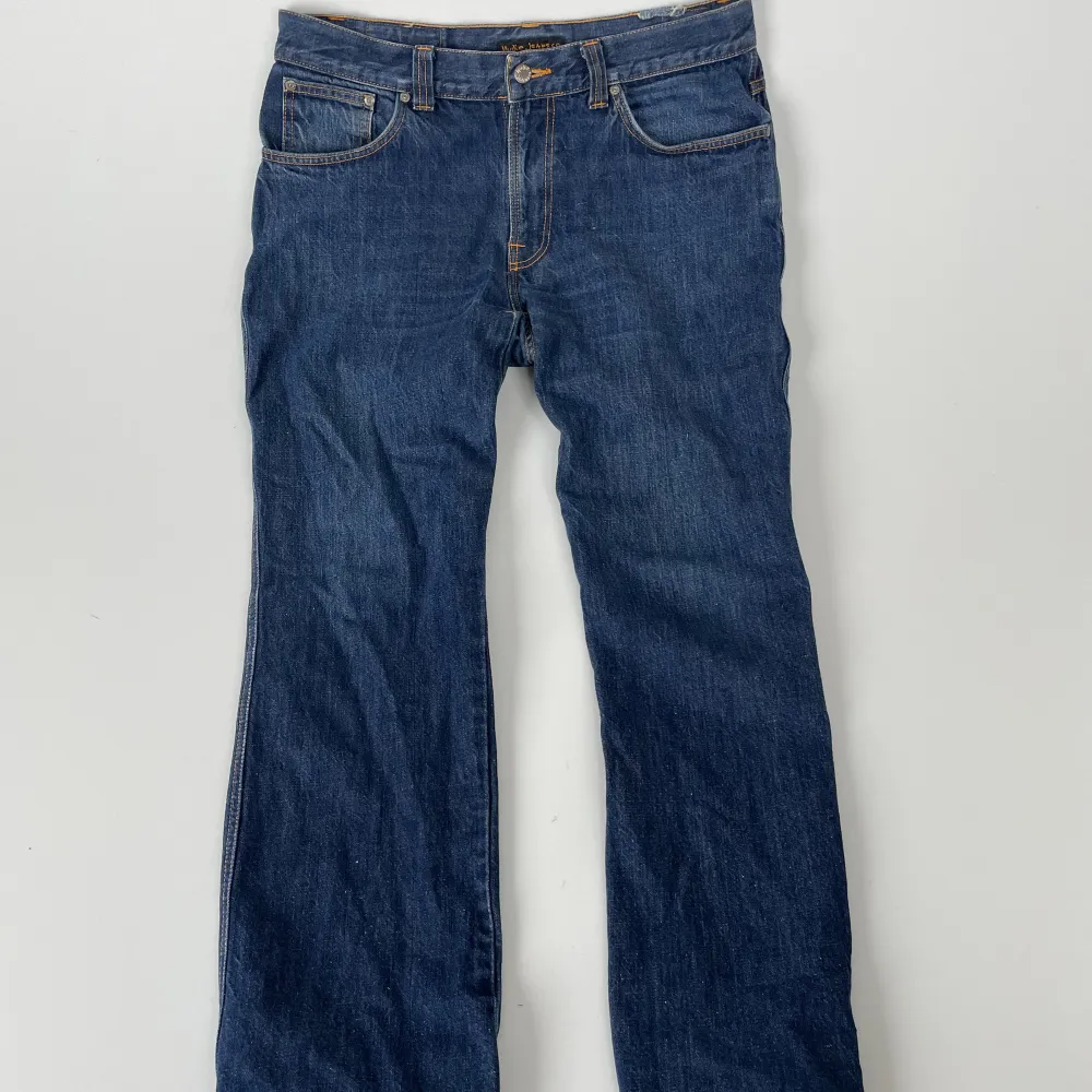 Förnya din garderob med ett par mörkblå Nudie jeans! Med sin djupa mörkblå färg ger det dig en elegant och mångsidi look som som är perfekta för alla tillfällen! Jeansen är väldigt stora i storleken och sitter som W32 L32. Jeans & Byxor.