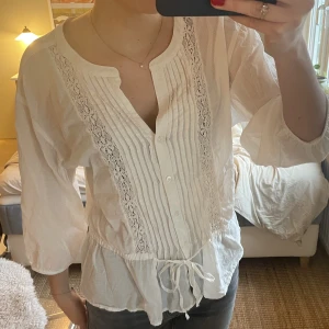 Långärmad vit blus - Vit blus köpt på second hand i strl. S. Gulliga detaljer och knytning vid midjan.🫶