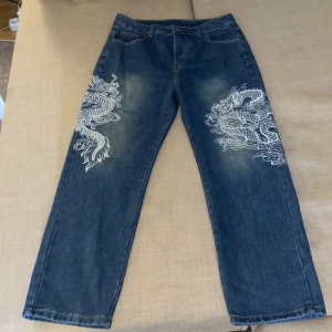 Drakebroderibyxor i blå  - Ett par blåa drakebroderibyxor de har väldigt bra material och har används ett par gånger och de är baggy. 