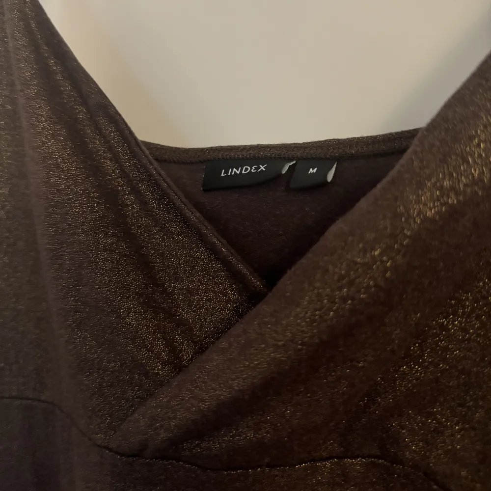 Ett brunt glittrigt linne från Lindex i storlek M.. Toppar.