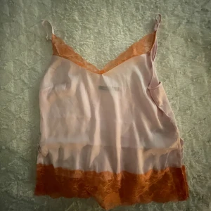 ljusrosa spetslinne i satin  - ett spetslinne i satin med rosa kanter, små slitsar på varje sida av toppen, köpt på gina i somras och använd bara en gång🩷