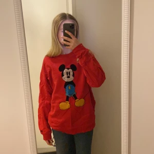 Röd levis tröja - Säljer en röd levis tröja med mussepigg på framsida samt baksida för att den inte kommer till användning längre!  (Inte jag på bilden)