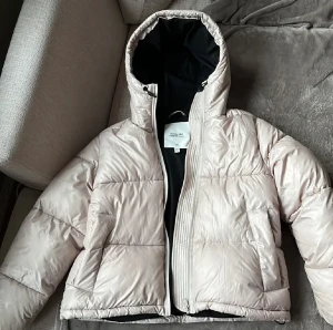 Dunjacka H&M  - Dunjacka från H&M från deras kollektion förra året där man fick designa sin egen jacka, Designed by me.  Vit-beige pärlemoraktig färg. I väldigt fint skick, endast använd 2 ggr. 