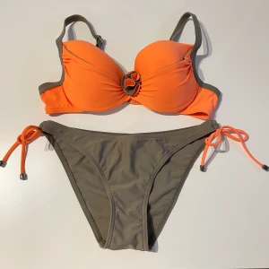 Ny Bikini - Svinsnygg ny bikini från Lorin som jag endast säljer då överdelen ej passar mig! Den är orange och olivgrön med en snygg ”Blom”-detalj! Överdelen är 75d men sitter som en 70c enligt mig, nederdelen i storlek 38 men passar även 36!⭐️❤️