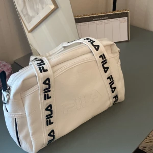 Vit filaväska som ny  - Aldrig använt denna så som ny, tillkommer ett axelrämsband som man kan sätta på om man inte vill ha den som en handväska🌟