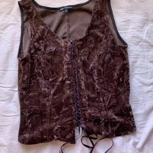 korsettliknande brun sammet topp - ÄLSKAR denna så mkt, använt den ganska mycket men den kvaliten har inte blivit sämre, den är så unik och ger korsett vibes och har snörning , använd den på kjolar och jeans