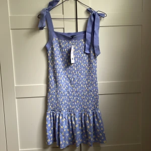 Lila smockad klänning - Lavendellila klänning från French Connection i storlek S. Står att den är blå men skulle säga lila. Smockad i strukturen med en liten volang nedtill. Helt oanvänd med prislappen kvar. Ordinarie pris 1099 kr. Säljer den för 400 kr. Köparen står för frakt💕