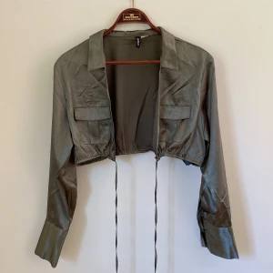 grön topp - en glansig grön topp med knyt. helt oanvänd, enbart tvättad.