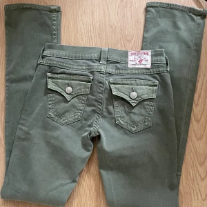 True religion LÅNGA lågmidjade gröna - Dessa byxor är lågmidjade straight fit militärgröna true religion!! Skiiitsnygga Midjemåttet är 33x2  Innerbenslängden är 83 cm ( de passar på långa personer) De är i nyskick, inga defekter.