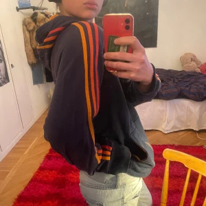 Adidas zipup - Assnygg adidaszip up med röd/orange/gula ränder. Storlek M