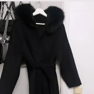 Lång svart kappa med äkta päls  - Säljer min splitternya oanvända långa svarta kappa med äkta fluffig päls i storlek S men passar även XS. Fick den som en tidig julklapp men tyvärr var det fel modell då jag vill ha den korta därav säljer jag den. 