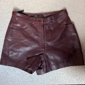 Lädershorts  - Säljer dessa skinnshort eller lädershorts. De är brun/vinröda, Snygg färg!  