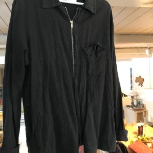 Overshirt L’homme rouge - Svart Overshirt från L’Homme Rouge, med dragkejda, fickor och bröstficka. 50% Linne, 50% Bomull. Sparsamt använd och i gott skick.  