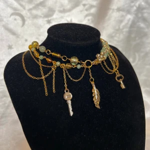 Handgjort halsband  - Asymmetriskt grönt och guldigt halsband. Förlängningskedja finns:) Omkrets som minst: 44cm Omkrets som störst: 48cm