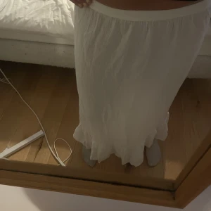 Långkjol  - Vit lång kjol från vero Moda med volang längst ner. Helt oanvänd bara testad. Säljer för att den är för kort på mig (175). Går till anklarna på mig! Andra bilden är modellen fast den är vit (slut online). 200kr+frakt pris kan diskuteras