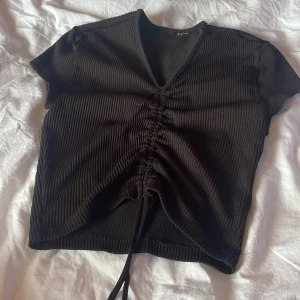 T-shirt - En svart t-shirt men knytning på magen