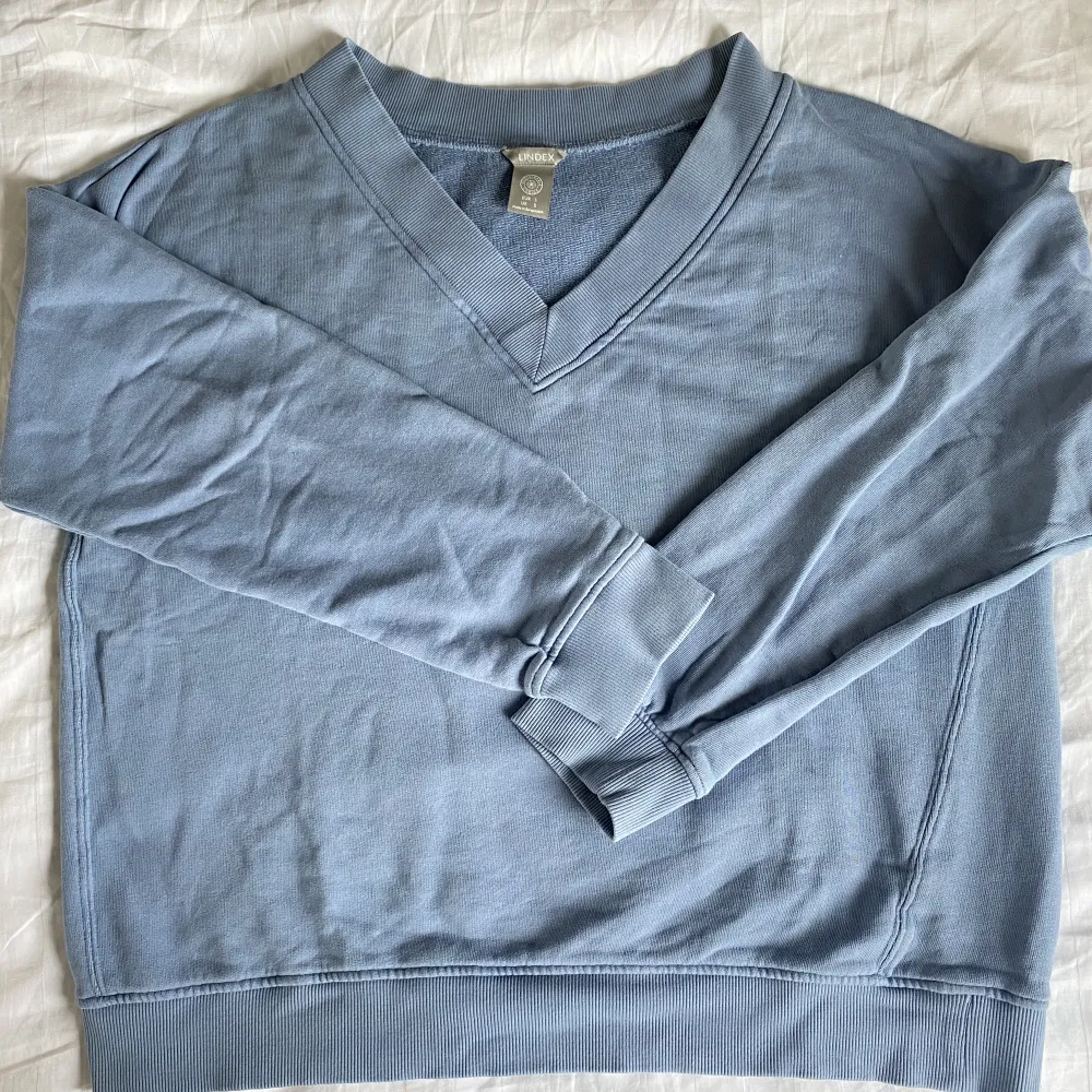 Blå sweatshirt med vringning från Lindex. Tröjor & Koftor.
