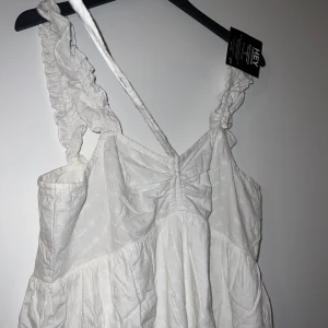 Klänning Nelly  - (Fler bilder kan tas, klänning är hel vit)  Fin klänning från Nelly, jätte fin till sommaren tyvärr blir den ej använd här så den får gå vidare, klänningen är i ett fint tyg med snören man kan justera och knyta, klänningen är i storlek 44 