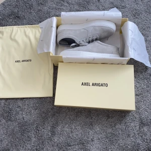 Axel Arigato skor - Ljusgrå Axel Arigato skor, sprillans nya (oanvända), kom privat för fler bilder, du får all tillbehör (påse, klistermärken, lådan). 2100kr + frakt, strl 42, 