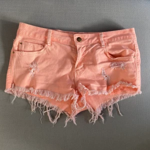 Lågmidjade shorts - Korallrosa lågmidjade shorts, så najs när man är brun! Svårt att fånga färgen på bild, de två andra bilderna gör färgen mer rättvis. Frakt ingår inte 
