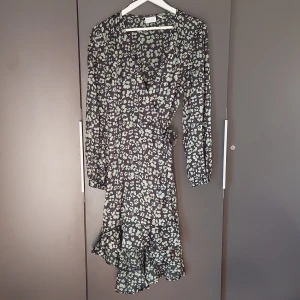 Blommig klänning - Fin klänning, jag har bara för många. Storlek 38-40. Det saknas en knapp men kan fixas med en säkerhetsnåla.
