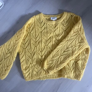 Stickad tröja - Gul stickad tröja. Ganska mönstrat så den blir lite genomskinlig mellan mönstret. Står storlek XS men passar mig som M