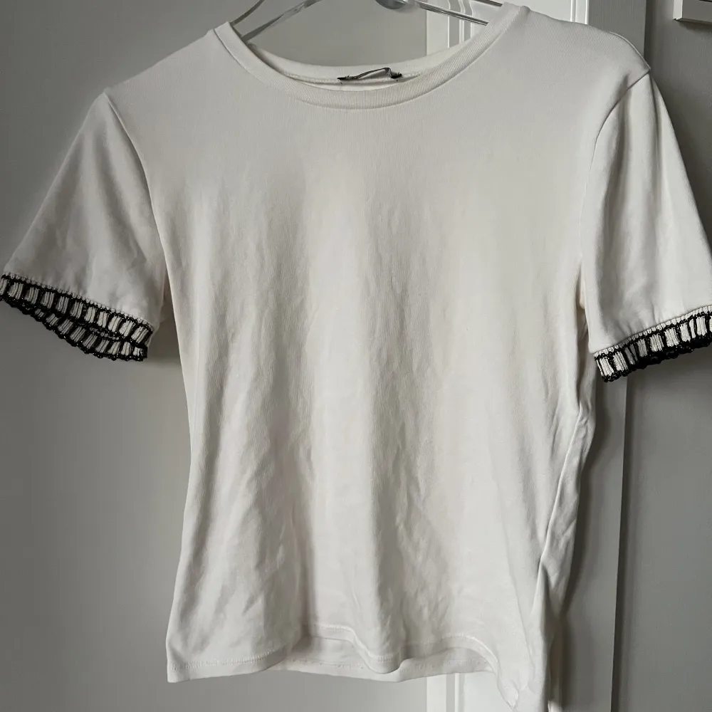 En vit t-shirt från Zara med detaljer vid armen i skick 9/10. Skriv gärna om du har några frågor! 🤍☺️. T-shirts.