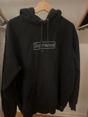 Supreme x Kaws hoodie, Svart - Använd ett par gånger och är i storlek M. Där finns inget fel med hoodien.  Kom privat för kvitto från stockX