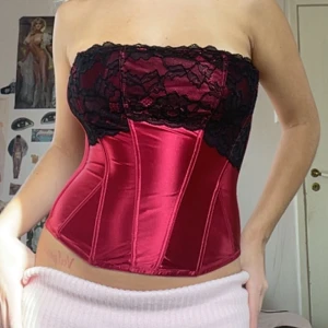 Röd korsett - Röd festlig korsett i fint skick. Står kupa A men skulle säga att den passar upp mot C