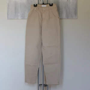Beiga mom jeans  - Jeans från mango  Strl: 34 (passar som 34-36) Mått: benlängd innersöm 67,5cm, midja 66cm, benöppning 16cm  Modell: Mom jeans, hög midja  Färg: Beige Skick: Fint skick  Material: 100% bomull OBS. Hund i hemmet 