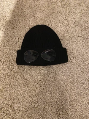 Cp.Company Mössa - Tjena! Säljer nu min Cp Company Väldigt bra skick men liten flaw på ögat som man ser endast på nära håll med blixt(dm för bild) Hör av er vid  frågor!(Pris kan diskuteras vid snabbaffär) Nypris 1200kr