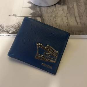Prada plånbok i blått saffiano-läder, inte använd på länge. Köpt i Prada-butiken i Stockholm. Nypris runt 7 000kr.