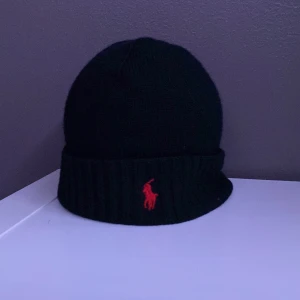 Polo ralph lauren mössa  - Polo ralph lauren mössa | Svart med rött märke | använd i gott skick och finns inga kännetecken på användning | pris 250 kr |